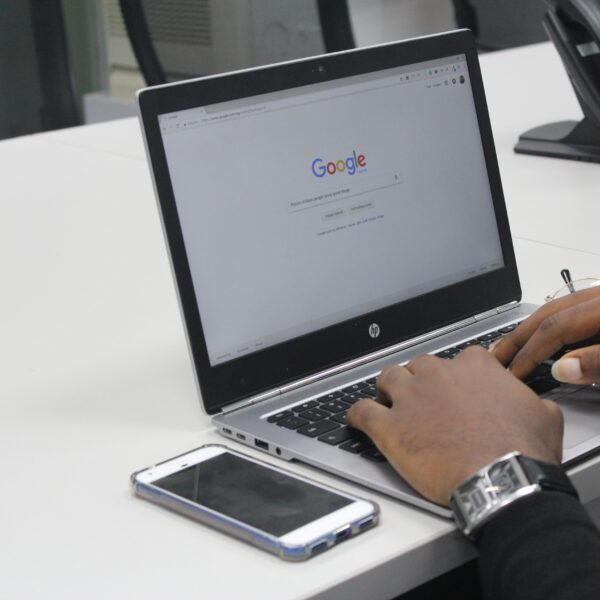 Man Typing on Google on a Laptop