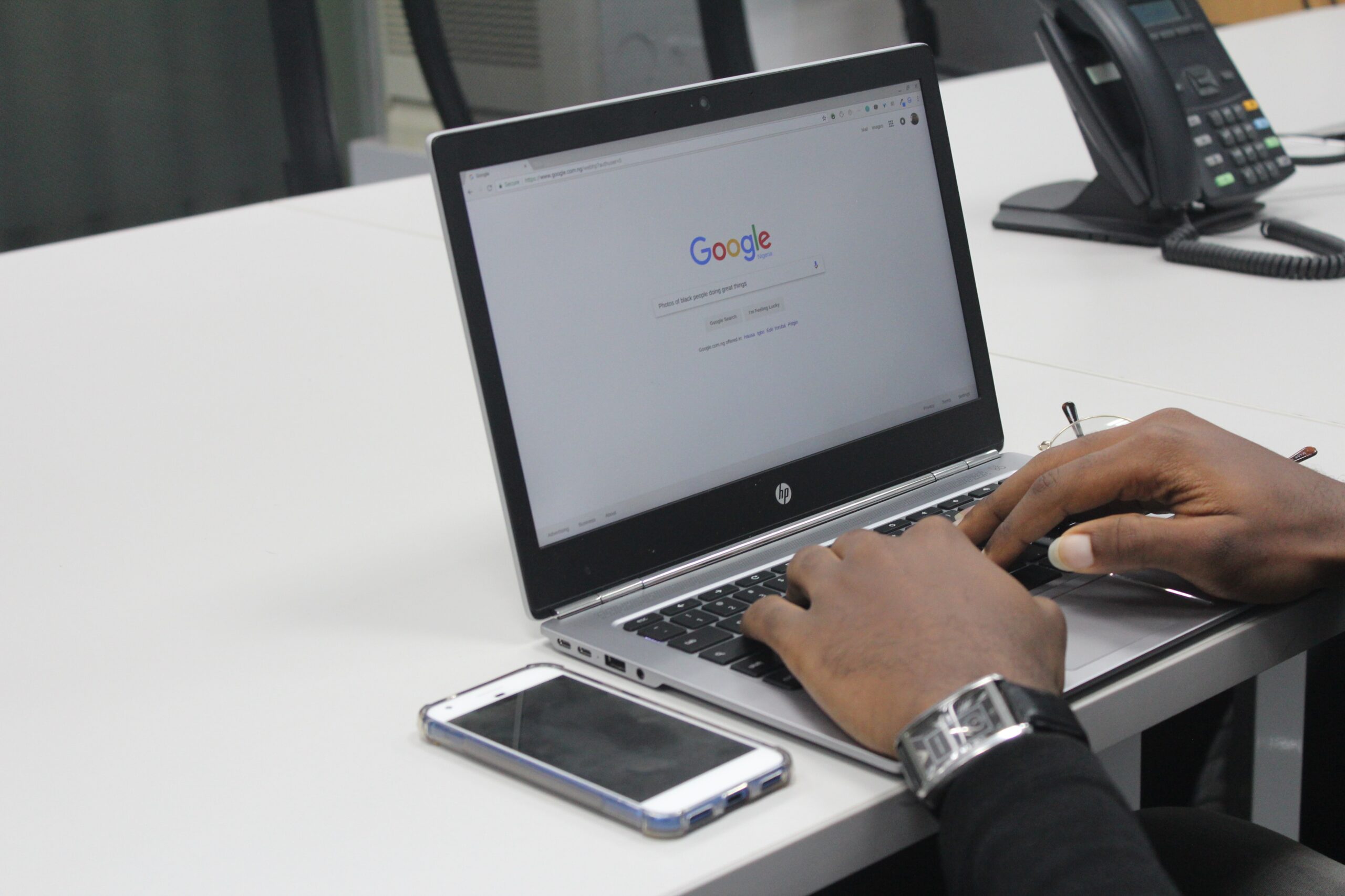 Man Typing on Google on a Laptop